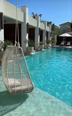 a hammock hanging from the side of a swimming pool next to a building