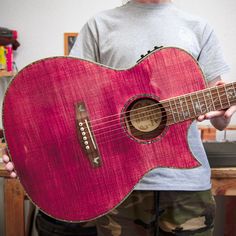 a man holding a red guitar in his hands