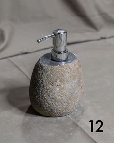 a soap dispenser sitting on top of a rock