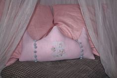 a bed with pink and white pillows on top of it