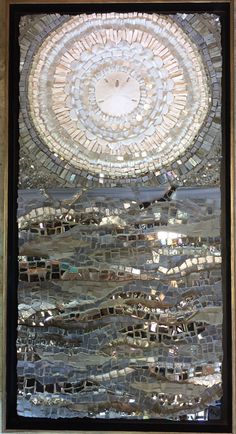 a window with a circular design made out of glass and silver foil on the outside