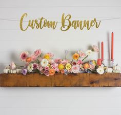 a wooden shelf with flowers and candles on it that says custom banner over the top