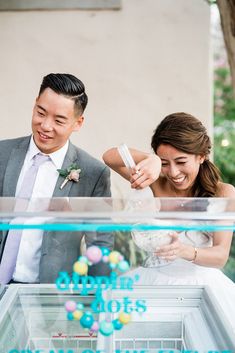 a man and woman standing next to each other in front of an ice cream cart