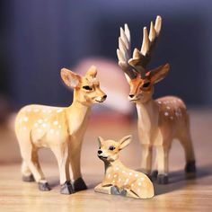 two deer figurines sitting next to each other on a table