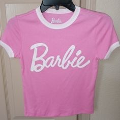 Barbie T-Shirt. Pink Trimmed In White. Size Xs. Basic Logo Print Top For Spring, Basic Spring Top With Logo Print, 90s Pink Tops With Logo Print, Pink 90s Logo Print Tops, 90s Pink Logo Print Tops, 90s Style Pink Tops With Logo Print, Cute Spring Tops With Logo Print, Cute Logo Print Tops For Spring, Basic Logo Print T-shirt For Spring