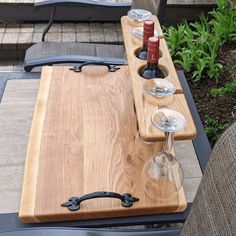 two wine glasses are sitting on a wooden tray