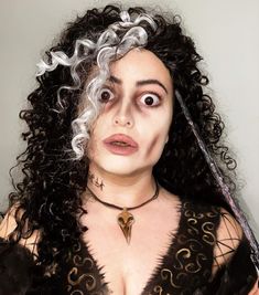 a woman with curly hair and makeup is holding a knife in her hand while looking surprised