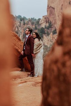 a man and woman are standing in the desert