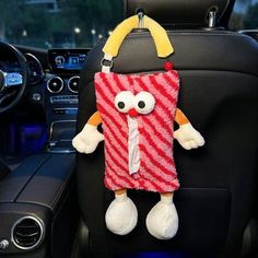 a stuffed animal is sitting in the front seat of a car with its head hanging out