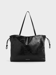 Need a new tote? The Bethel tote is the perfect choice. Featuring a distinctive crinkle-effect texture, it adds visual interest to the classic black finish. Opening up to a spacious interior, you will be able to carry all that you need around while keeping them organised with the inner pockets. As an enhanced security feature, the bag comes with both a magnetic closure and drawstring ties to keep your belongings safe. Versatile Black Shoulder Bag With Rolled Handles, Casual Black Shoulder Bag With Rolled Handles, Drawstring Tote Bag, Charles And Keith, Fall Fits, Charles Keith, Black Tote Bag, Kids Gifts, Magnetic Closure