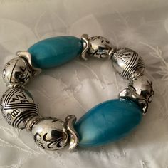 This is a Vintage Chunky Stretch Bracelet.  Nice piece of Costume Jewelry to wear with anything.  It has 2 Large Aqua Pearlized Beads and 6 Silvertone Patterned Ball Beads with Separators.  It is Huge but Lightweight and fit just right on a small to Medium wrist but would also fit a larger Wrist.  It's quite a Statement piece and reasonably priced!  Enjoy!  Great Gift! Vintage Turquoise Round Bead Bracelets, Vintage Adjustable Beaded Bracelets With Spacer Beads, Vintage Adjustable Bracelets With Large Beads, Vintage Large Beads Bracelet, Vintage Adjustable Stretch Bracelet With Large Beads, Vintage Adjustable Bracelet With Polished Beads, Vintage Adjustable Bracelets With Polished Beads, Vintage Adjustable Bracelets With Silver Beads, Vintage Adjustable Beaded Bracelets With Silver Beads