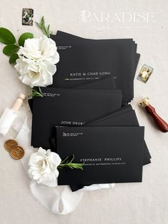 black envelopes with white flowers and wax stamp