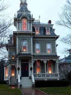 an old victorian style house with lights on