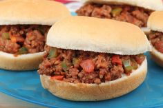 four sloppy joe sandwiches on a blue plate