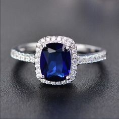 an engagement ring with a cushion cut blue sapphire surrounded by pave diamond halos