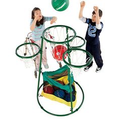 two children are playing with a ball and basketball hoop