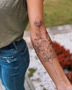 a woman's arm with a flower tattoo on the left side of her arm