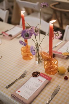 the table is set with flowers, candles and menus for an elegant dinner party