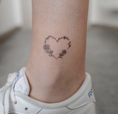 a small heart tattoo on the ankle