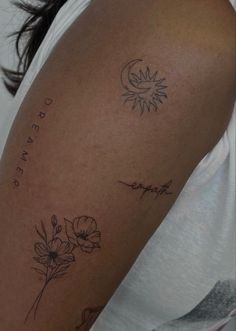 a woman's arm with flowers and the word love written in cursive writing