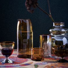 a table topped with vases and glasses filled with liquid