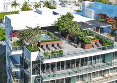 an aerial view of a rooftop garden with lounge chairs and trees in the foreground