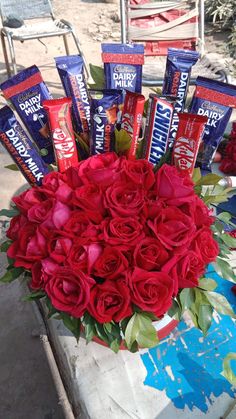 a bouquet of roses and chocolate bars on a table