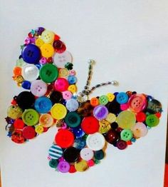 a butterfly made out of buttons sitting on top of a piece of paper