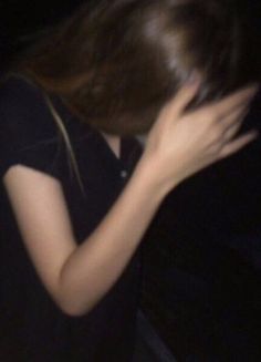 a blurry photo of a woman with her hair blowing in the wind at night