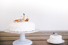 two small white cakes sitting on top of a wooden table