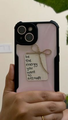 a person holding up a cell phone case with a message on it that says, be the energy you want to attract