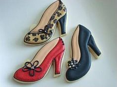 three decorated cookies in the shape of women's shoes and high heeled shoes