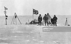 some people standing in the snow with flags and an old fashioned tent on top of it