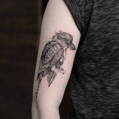 a black and white bird tattoo on the arm