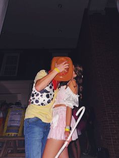 a man and woman are dancing on the dancefloor with an orange frisbee