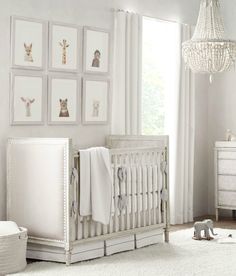 a baby's room with white walls and pictures on the wall