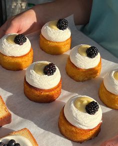 there are many desserts on the tray ready to be eaten by someone's hands