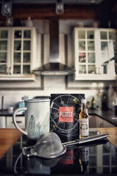 a bottle of beer sitting on top of a counter next to a pot and pan