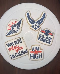 decorated cookies on top of a white plate with air force sayings and symbols in red, white, and blue