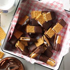 there are many pieces of chocolate and marshmallows in the tray on the table