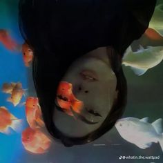 a woman's face surrounded by fish in an aquarium