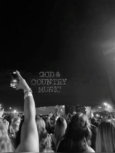 a crowd of people at a concert with the words god and country music above them