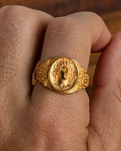 The Helios 18K Gold Signet Ring draws inspiration from the ancient Greek sun god Helios, who symbolized power, radiance, and vitality as he rode his golden chariot across the sky each day. This stunning 18K gold ring captures the timeless brilliance and enduring strength associated with the solar deity, making it a perfect choice for those seeking a piece of jewelry that embodies the spirit of ancient mythology and luxurious craftsmanship. Spiritual Yellow Gold Signet Ring, Gold Spiritual Signet Ring For Ceremonial Occasions, Vintage Gold Ring With Halo, Collectible Gold Rings With Historical Design, Gold Byzantine Signet Ring For Ceremonies, Gold Byzantine Signet Ring For Ceremonial Occasions, Gold Byzantine Style Ceremonial Signet Ring, Greek Sun God, Mens Emerald Rings