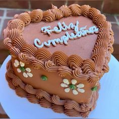 a heart shaped cake with the words happy birthday written on it and almonds in the icing