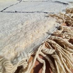 a close up of a blanket on the ground with other blankets and rugs in the background