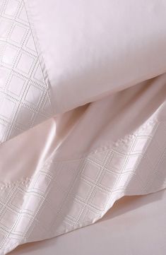 the sheets and pillowcases are made up with white stitching on them,