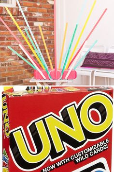 uno card game box sitting in front of a mirror with colorful sticks sticking out of it