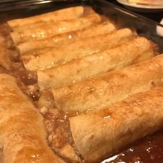 some very tasty looking food items in a pan on a table with other foods