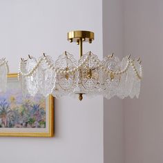 a chandelier hanging from the ceiling in a room with paintings on the wall