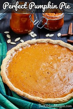 a pumpkin pie sitting on top of a table next to some cinnamons and spices